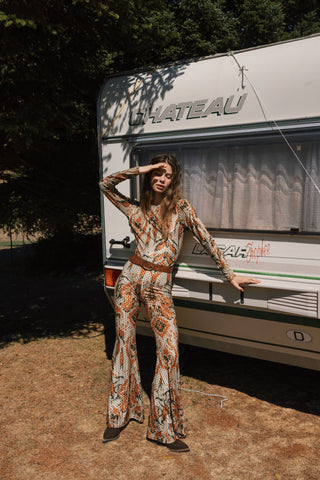Woman in a patterned outfit standing in front of a trailer with 'Chateau' branding.